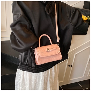 Detail of pink faux leather crossbody bag with buckle accent and adjustable strap
