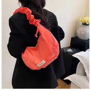 Vue détaillée arrière d'un sac bandoulière croissant orange corail avec bandoulière plissée