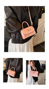 Detail of pink faux leather crossbody bag showing handle and adjustable shoulder strap