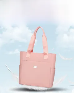 Detailed view of lightweight pink tote bag featuring multi-pocket layout and wide straps