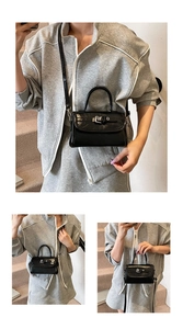 Detail of glossy black patent leather mini crossbody bag with silver metal buckle