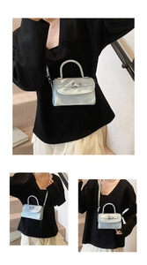 Model styling a metallic light blue mini crossbody bag with top handle and silver buckle