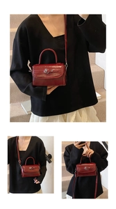 Detail view of burgundy patent leather mini square bag with polished top handle and strap