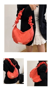 Détails du sac hobo plissé orange avec étiquette de mode et poignée à nœuds