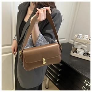 Détail d'un sac sous les bras vintage marron avec un fermoir ovale élégant en métal doré