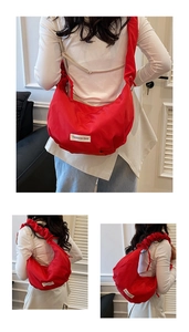 Détail du sac à bandoulière rouge plissé en tissu oxford avec large sangle réglable