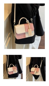 Detail view of a color-block crossbody bag with quilted pattern and shoulder strap