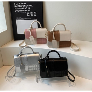Detail view of four textured crossbody bags in pink, brown, silver and black colors