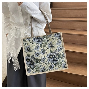 Detail of floral jacquard linen tote bag with brown handles and reinforced white piping