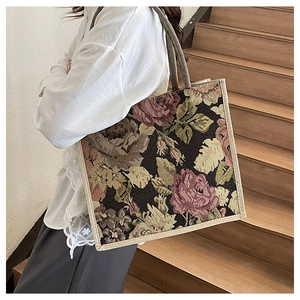 Detail of vintage floral jacquard tote bag with textured linen handles on a shoulder strap