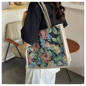 Detailed close-up of large linen tote bag with vintage floral embroidery and woven texture