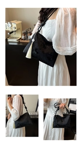 Détail du tissu jacquard papillon noir et du charme à pompon blanc sur le sac à bandoulière
