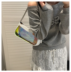 Close-up of holographic PVC underarm bag on model with white leather trim