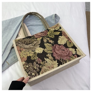 Detail of floral tapestry linen tote bag with vintage rose patterns and woven handles