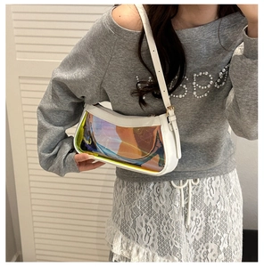 Iridescent laser PVC underarm bag with white leather frame worn on a model's shoulder