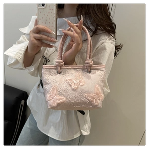 Detail of pink lace bucket bag with 3D butterfly embroidery and silver metal rings