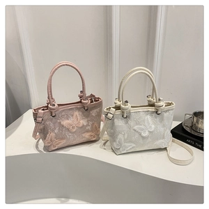 Detail view of pink and white bucket bags with lace embroidery and 3D butterfly appliqués