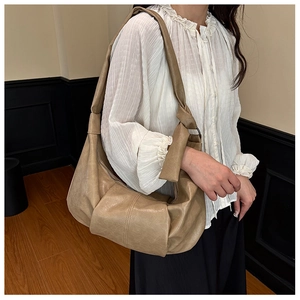 Side view of a soft khaki oversized dumpling shoulder bag with retro pleated leather texture