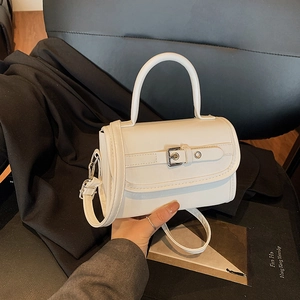 Elegant white patent leather crossbody handbag with top handle and decorative strap