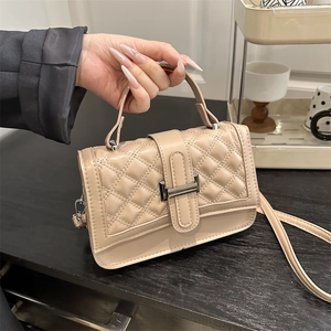 Quilted beige top-handle crossbody bag with elegant silver metal clasp and chain strap