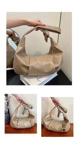 Detail of beige soft leather hobo bag featuring a knotted shoulder strap and pleated base