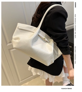 Borsa tote minimalista in pelle verniciata bianca con fibbia dorata su una modella