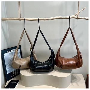 Detailed close-up of soft pleated leather hobo bags in beige, black and brown colors