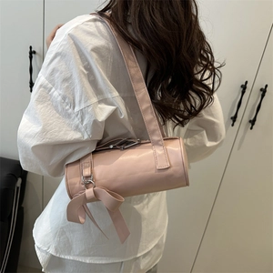 Sac Boston rose avec grand nœud décoratif et large bandoulière en similicuir mat