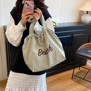 Light green drawstring tote bag with purple Beach lettering for casual daily use