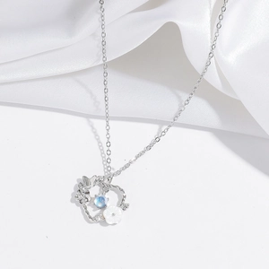 Elegant silver-toned heart flower necklace with zircons on white silk background