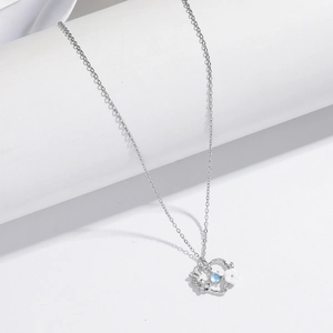 Macro shot of silver heart flower pendant with blue moonstone and white shell petal