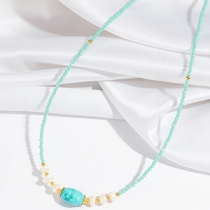 Detail of beaded necklace featuring turquoise stone, pearls and mint green beads