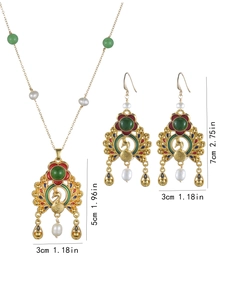 Detailed view of peacock pendant with colorful enamel, green gems and white pearls
