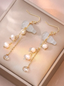 Detail of handmade gourd jade earrings with freshwater pearls and gold wire wrapping