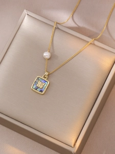 Detail of gold butterfly pendant with iridescent shell inlay and single side pearl