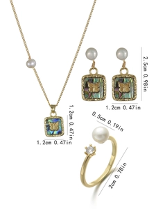 Detailed jewelry set with gold butterfly pendant, earrings, and pearl ring on white background