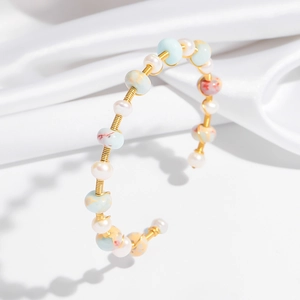 Handmade gold wire wrap bangle featuring natural pearls and marble textured beads