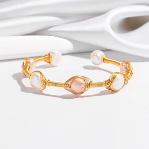 Detail of gold wire wrapped bangle with natural white and pink freshwater pearls