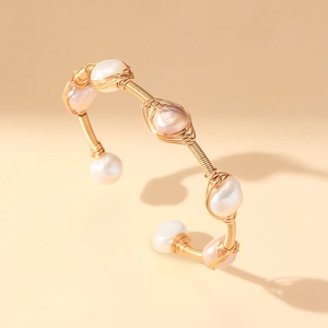 Artisanal gold wire-wrapped open cuff bracelet with baroque pearls in a minimalist design