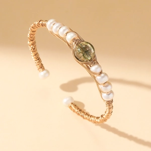 Handmade gold wire-wrapped open bangle with white pearls and a green rutilated quartz stone