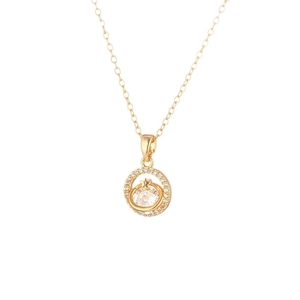 Collana dorata con pendente a stella e pianeta con zirconi su sfondo bianco