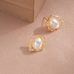 Boucles d'oreilles perles dorées avec bordure en zircon sur tissu texturé rose