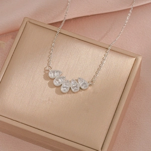 Elegant silver teardrop zircon fan pendant on a delicate steel chain over a jewelry box