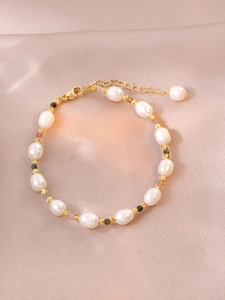 Detail of freshwater pearl bracelet with colorful tourmaline beads on silk background