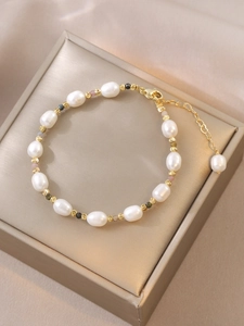 Detail of freshwater pearl bracelet with colorful tourmaline beads on gold jewelry box