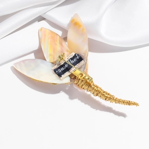 Exquisite shell flower brooch with gold wire wrap on white silk background
