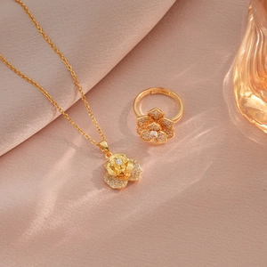 Parure fleur dorée avec zircons rotatifs sur le collier et la bague assortie