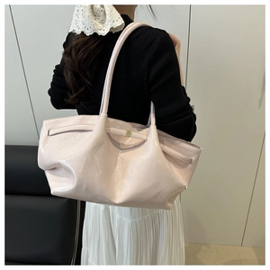 Side view of large pink patent leather tote bag with stylish pleated strap detail