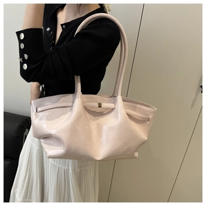Dettaglio della borsa tote in pelle verniciata rosa con texture morbida e fibbia oro