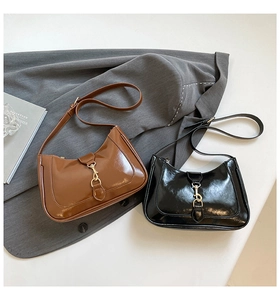Détail de sacs hobo en cuir verni marron et noir avec une boucle en métal vintage